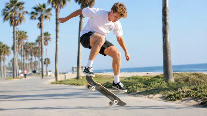 Ben Azelart skateboarding outdoors near a beach setting